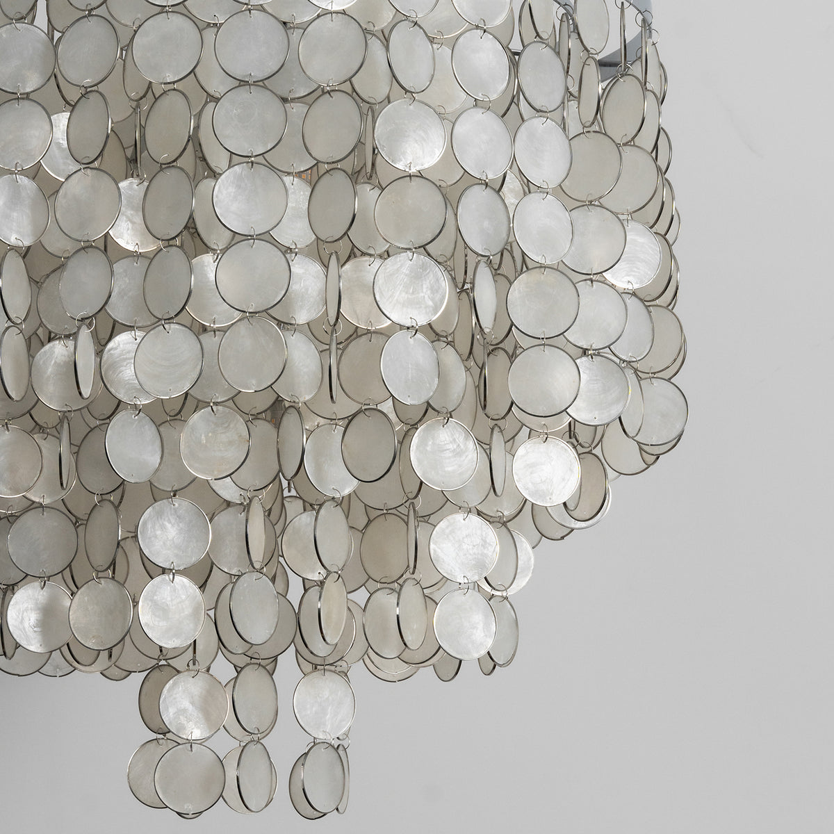 chandelier-layered-detail-metavaya Close-up of the tiered arrangement of natural capiz shell discs on the chandelier.