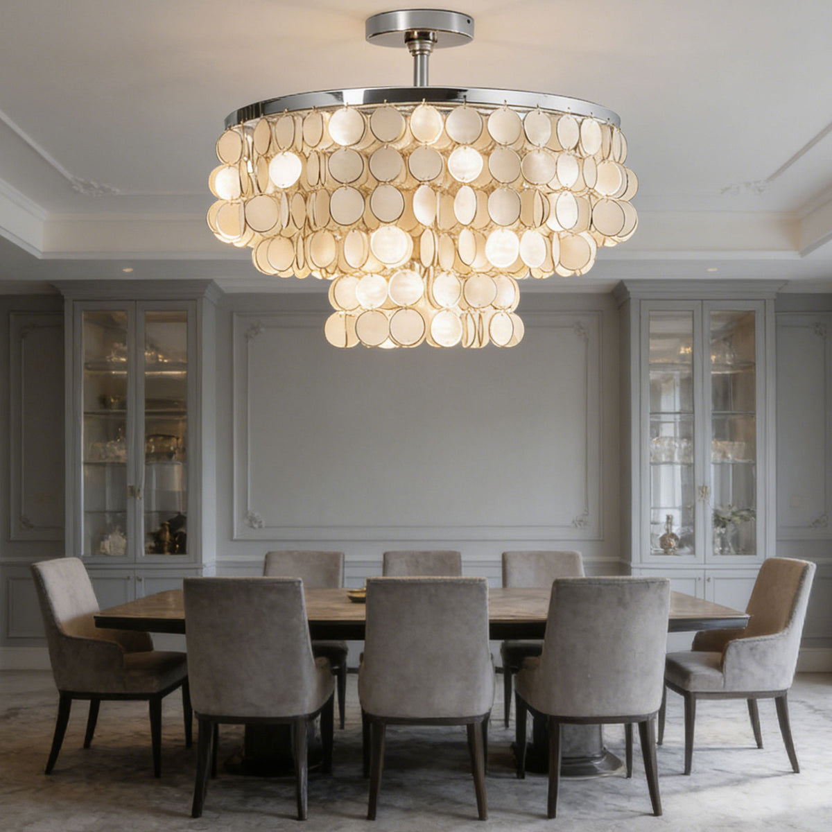 Tiered shell disc ceiling light above a round dining table in a classic formal dining room.