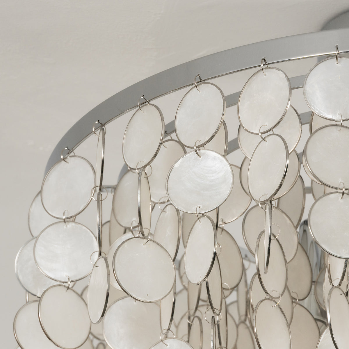Close-up of the tiered arrangement of capiz shell discs on the ceiling light.