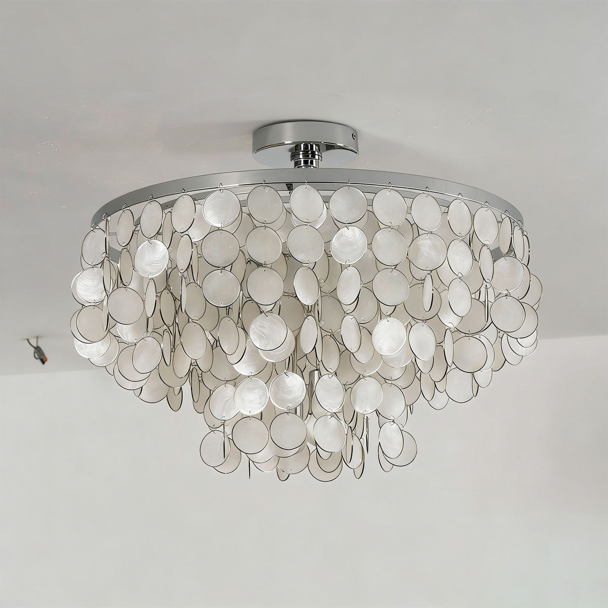 Side view of the tiered shell disc ceiling light on a white background, highlighting its cascading shell layers.