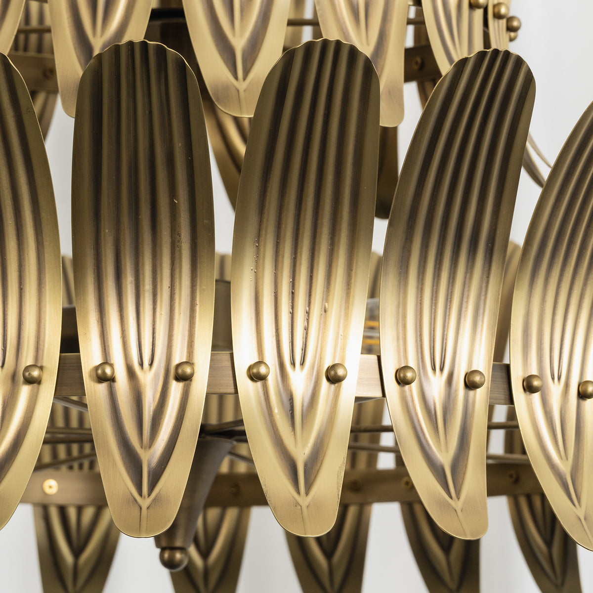 Close-up shot of the polished vintage brass finish and layered leaf structure of the chandelier.