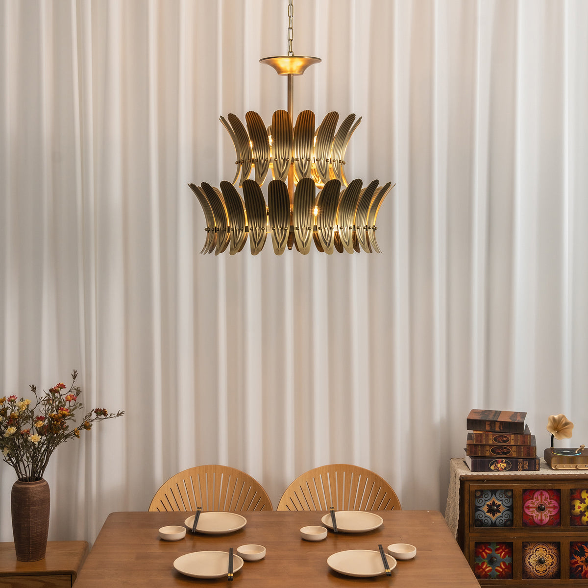 Vintage brass leaf chandelier viewed from a low angle above a set dining table.