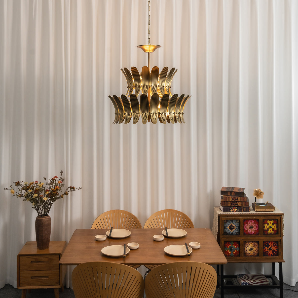 Vintage brass leaf chandelier above a small wooden dining table in a bright dining nook.