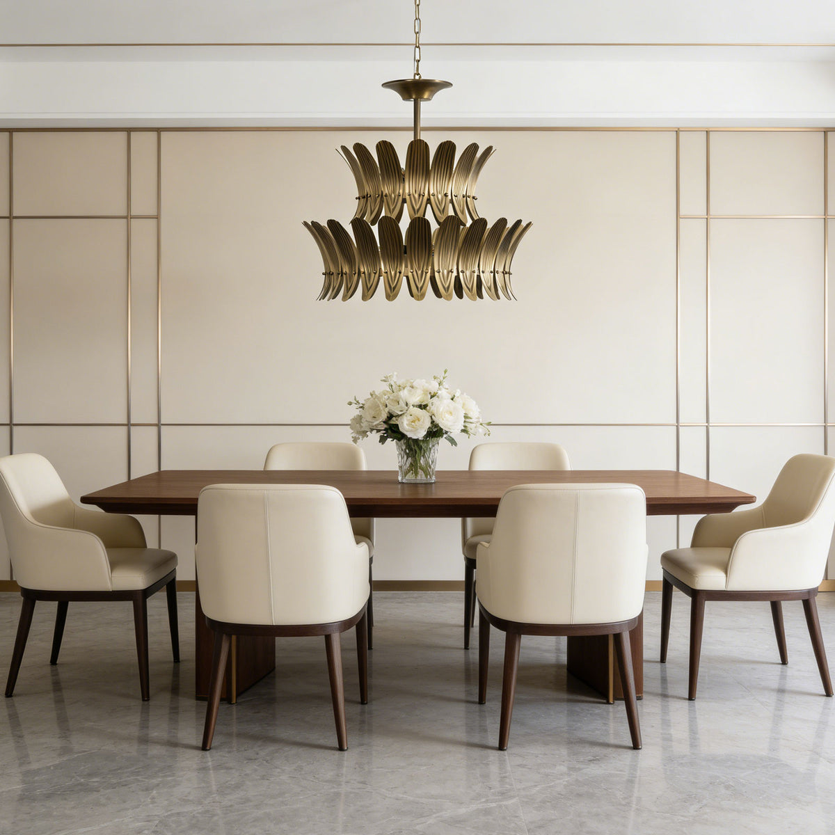 Vintage brass leaf chandelier hanging above a round wooden dining table in a minimalist dining room.