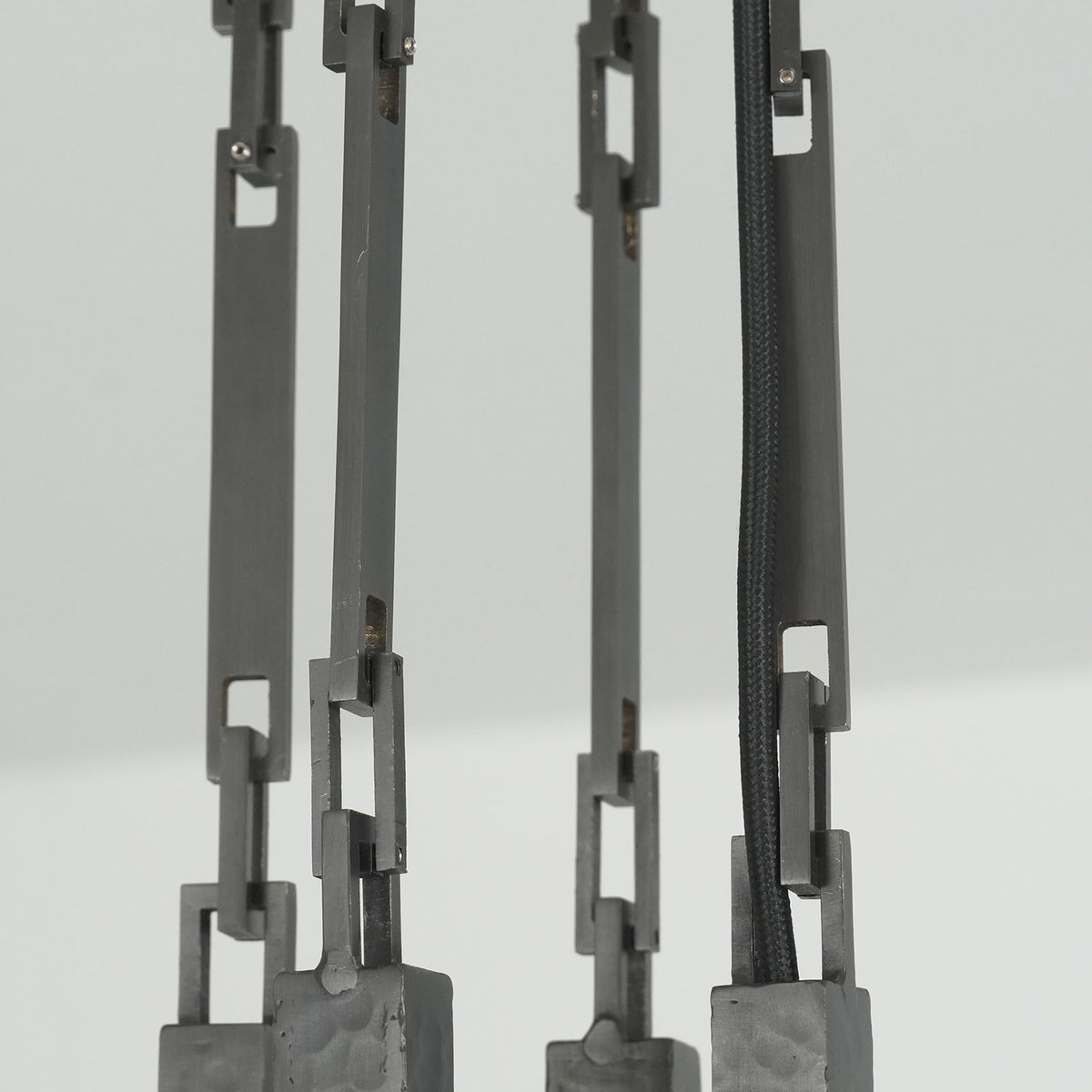 Close-up of the square black ceiling mount plate and hardware on the Wright-inspired chandelier.