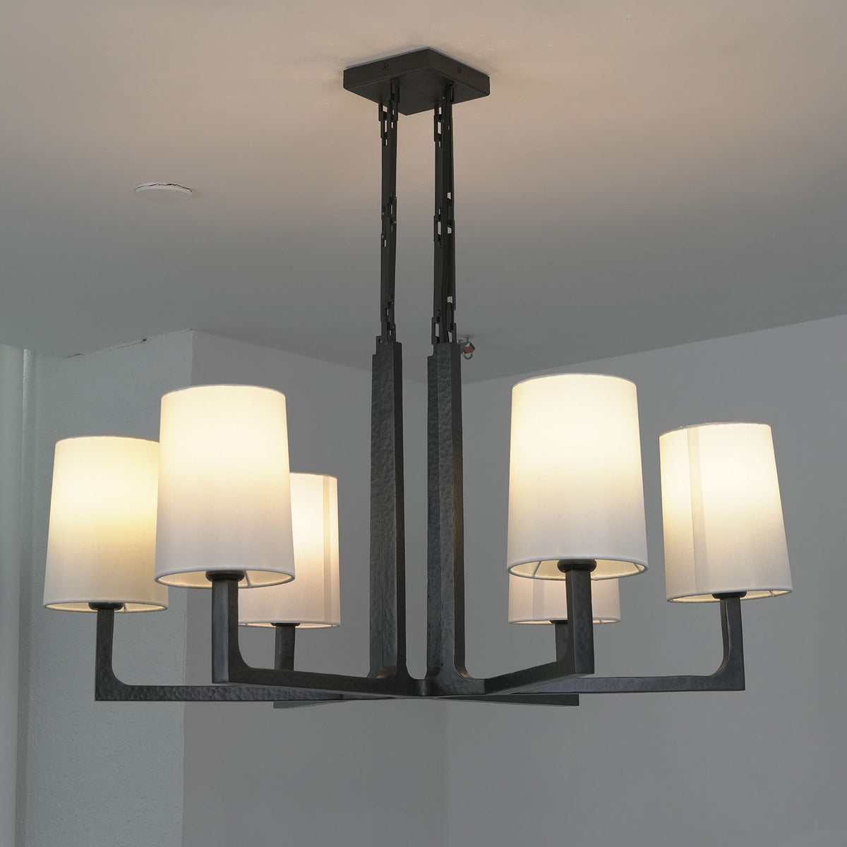 Close-up of the white fabric lampshade and black metal arm on the Wright-inspired chandelier.
