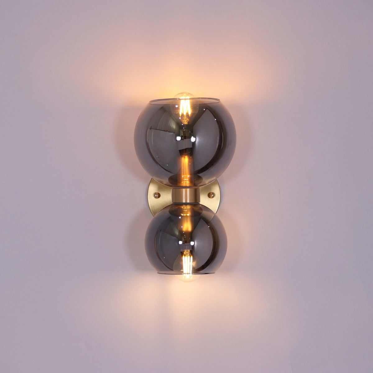 Modern crystal wall sconce with dual smoked glass globes and warm LED bulbs