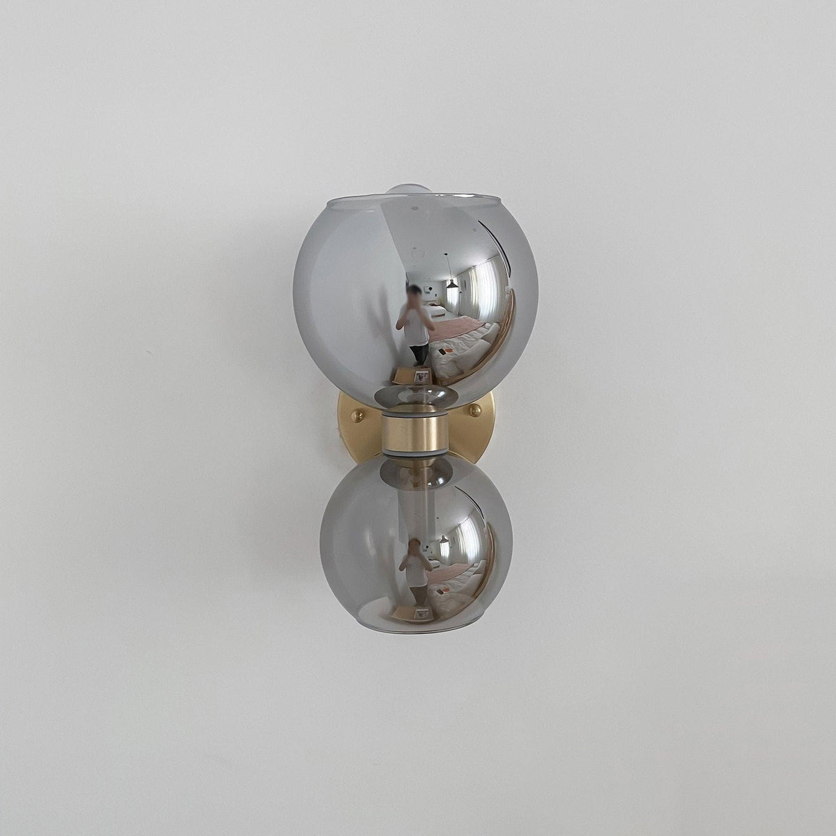 Modern crystal wall sconce with reflective spheres and gold accents for stylish home lighting