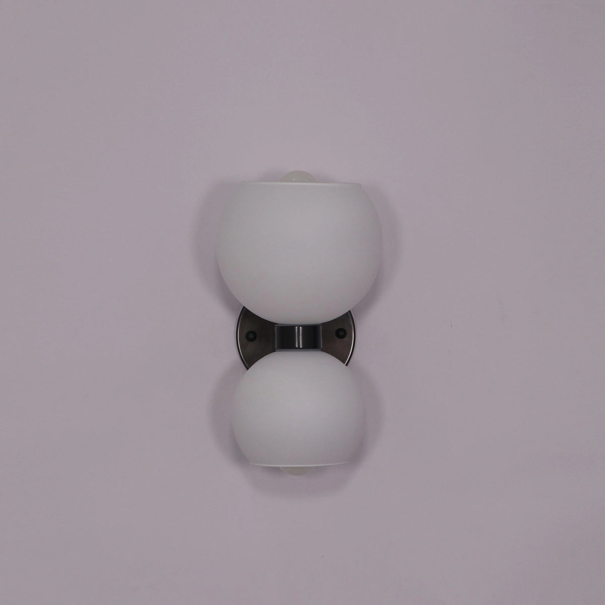 Modern wall sconce with frosted glass globes and sleek metal base