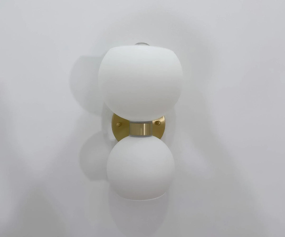 Modern wall sconce with frosted glass globes and brass finish for stylish home lighting