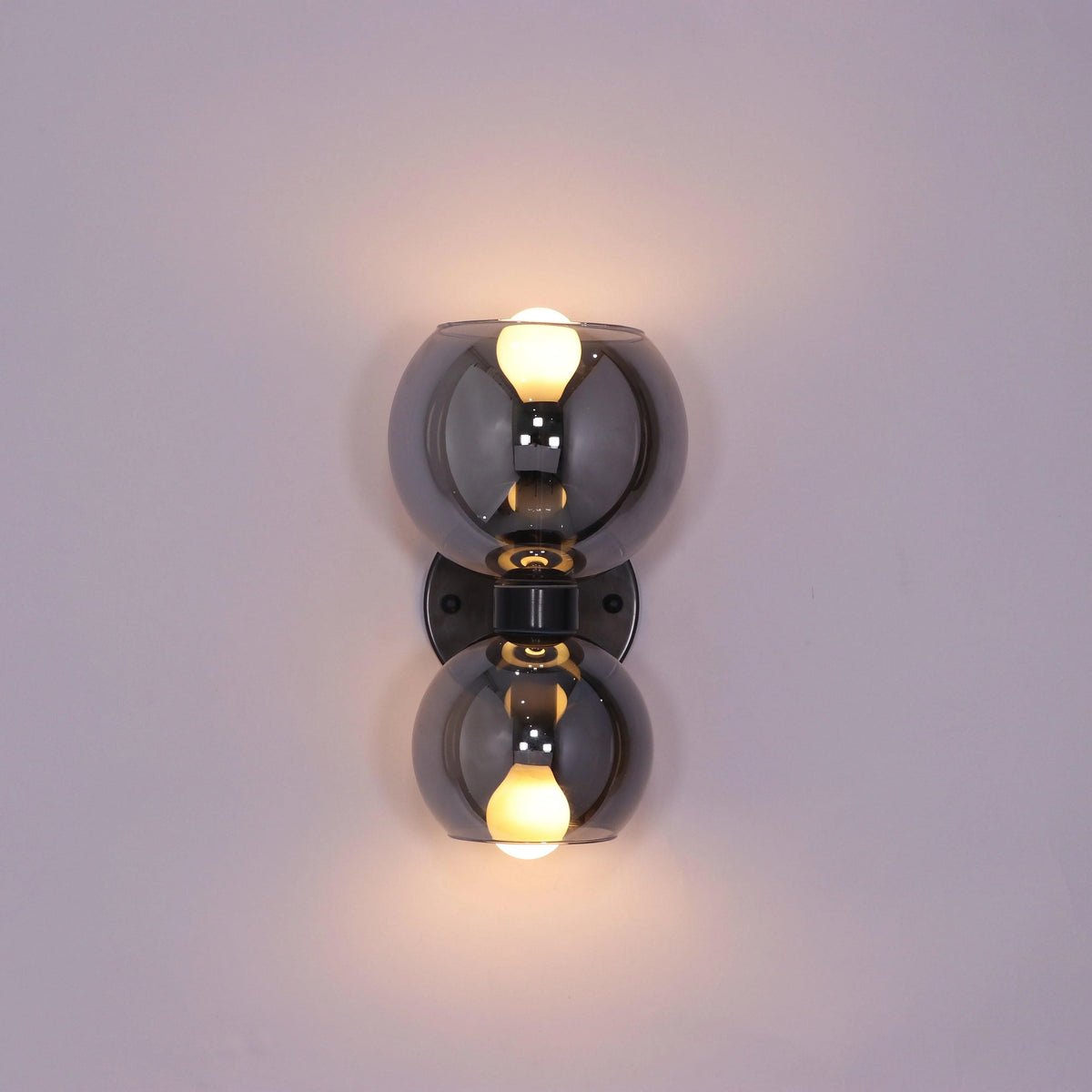 Modern wall sconce with smoked glass globes and warm LED bulbs for stylish interior lighting
