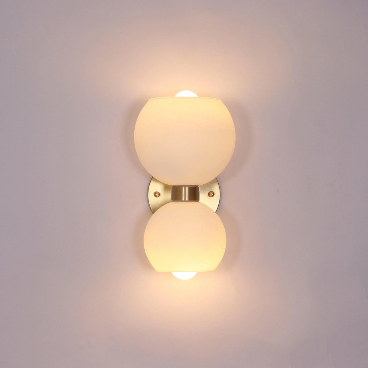 Modern wall sconce with frosted glass globes and brass finish for stylish home lighting