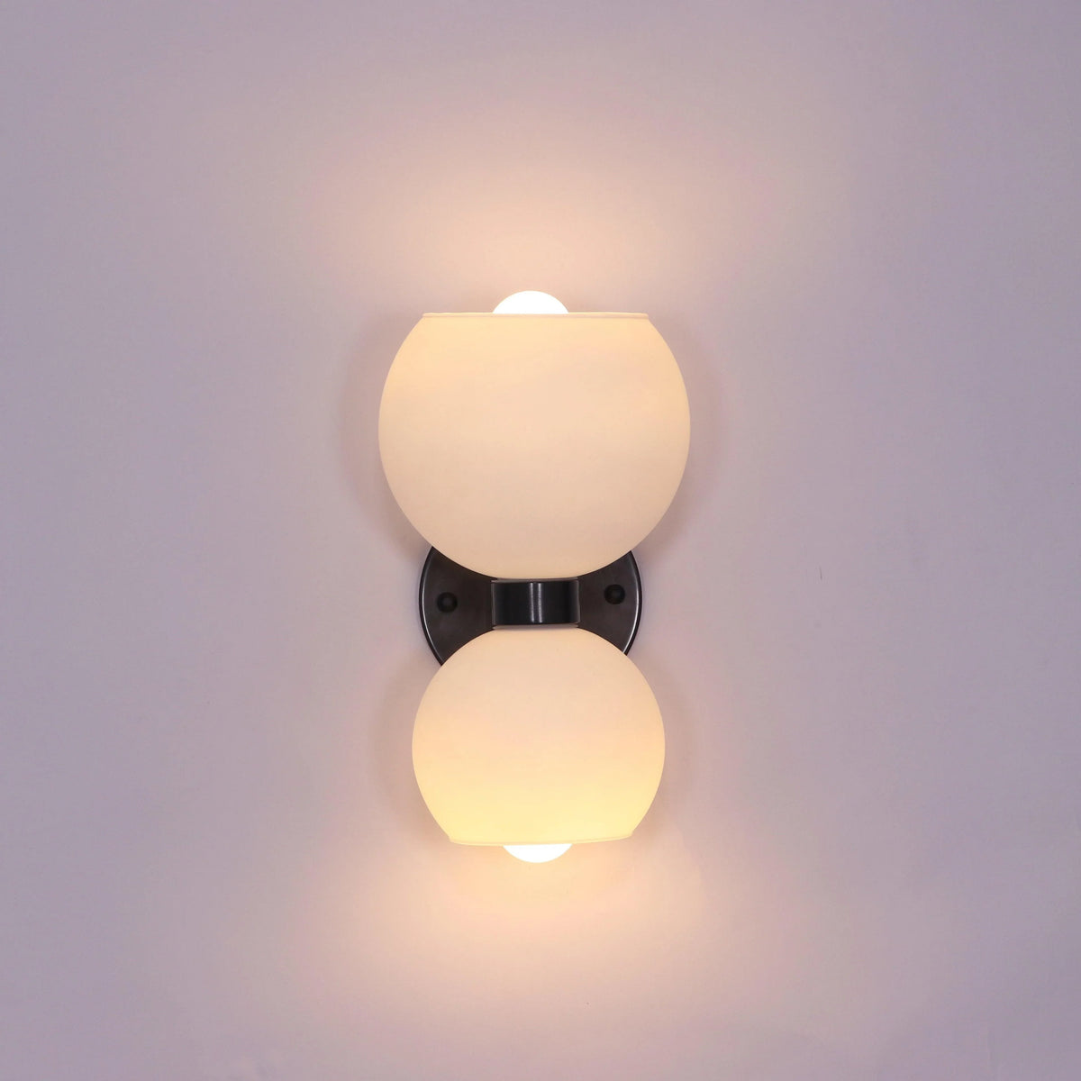 Modern wall sconce with frosted glass globes and sleek black mount for stylish interior lighting