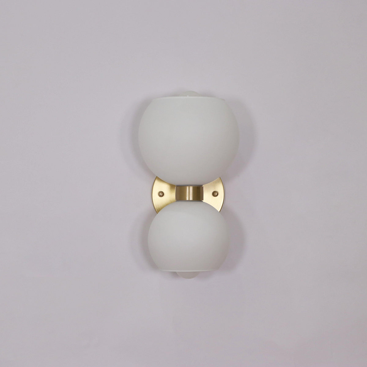 Modern wall sconce with frosted glass globes and brass finish for stylish home lighting