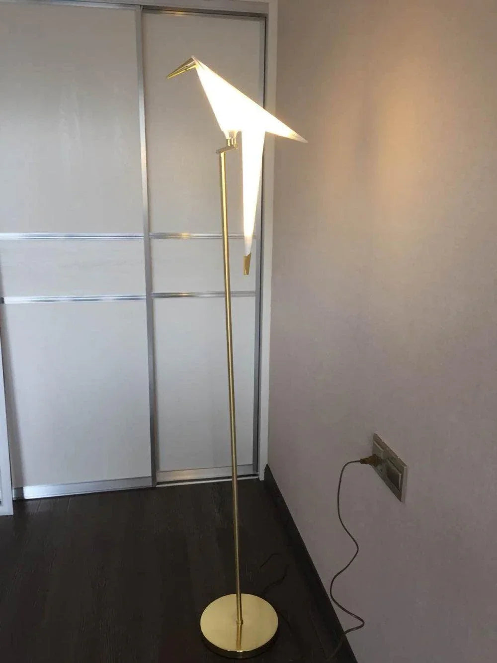 Modern gold floor lamp with bird-shaped white shade, sleek design for contemporary home lighting