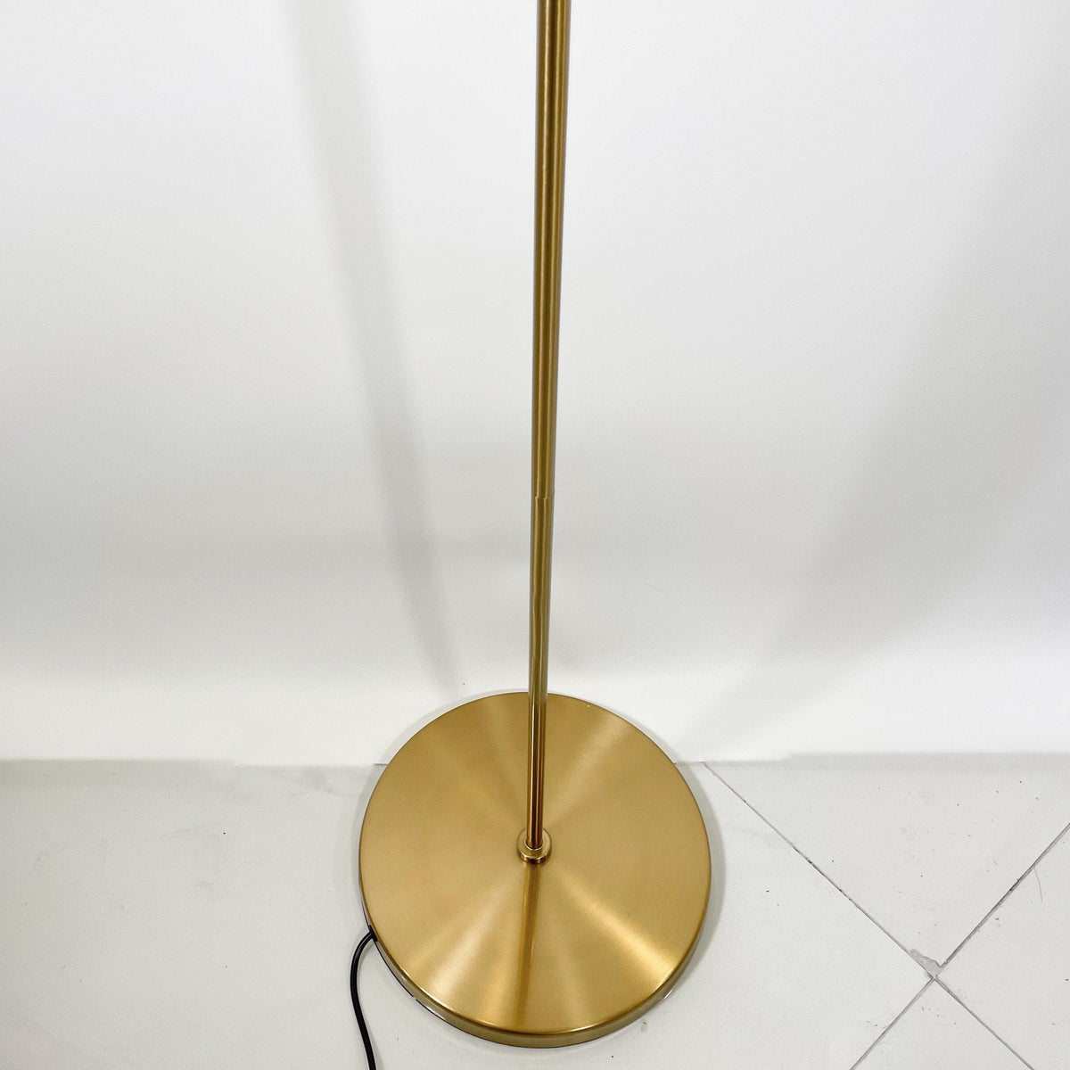 Modern brass floor lamp with sleek pole and circular base, stylish home lighting
