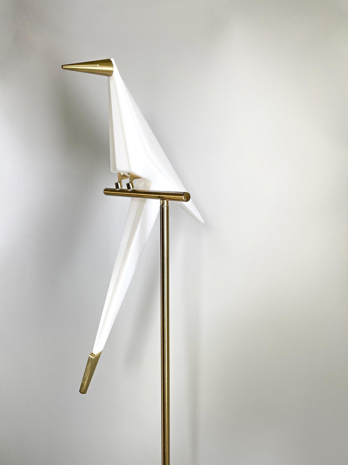 Modern white bird-shaped floor lamp with gold accents, stylish home lighting decor