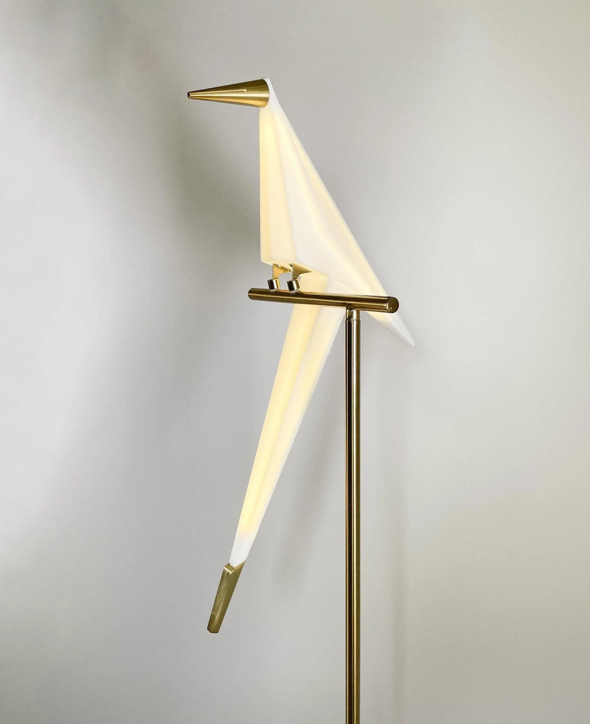 Modern bird-shaped floor lamp with gold accents and white diffuser, stylish home lighting design