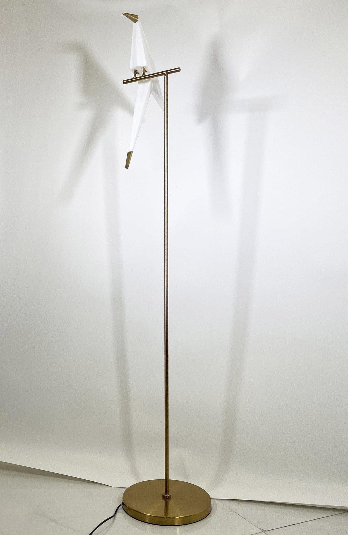 Modern brass floor lamp with white fabric shade, sleek design for contemporary home lighting