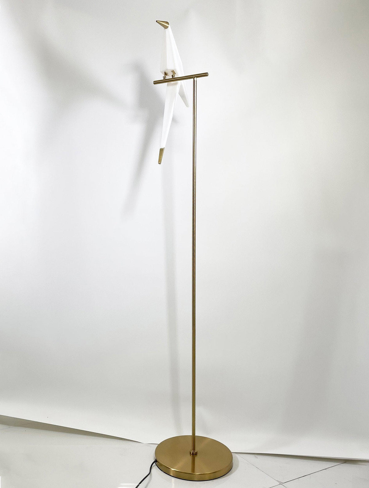 Modern brass floor lamp with white geometric shade, sleek minimalist design for contemporary spaces