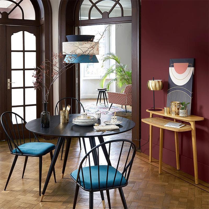 Modern dining room with black table, teal cushioned chairs, and stylish pendant lighting for elegant home decor
