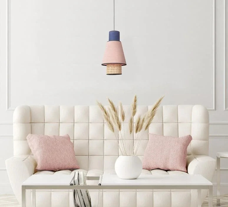 Modern pendant light with pink and blue shades over a cozy white sofa with pink pillows
