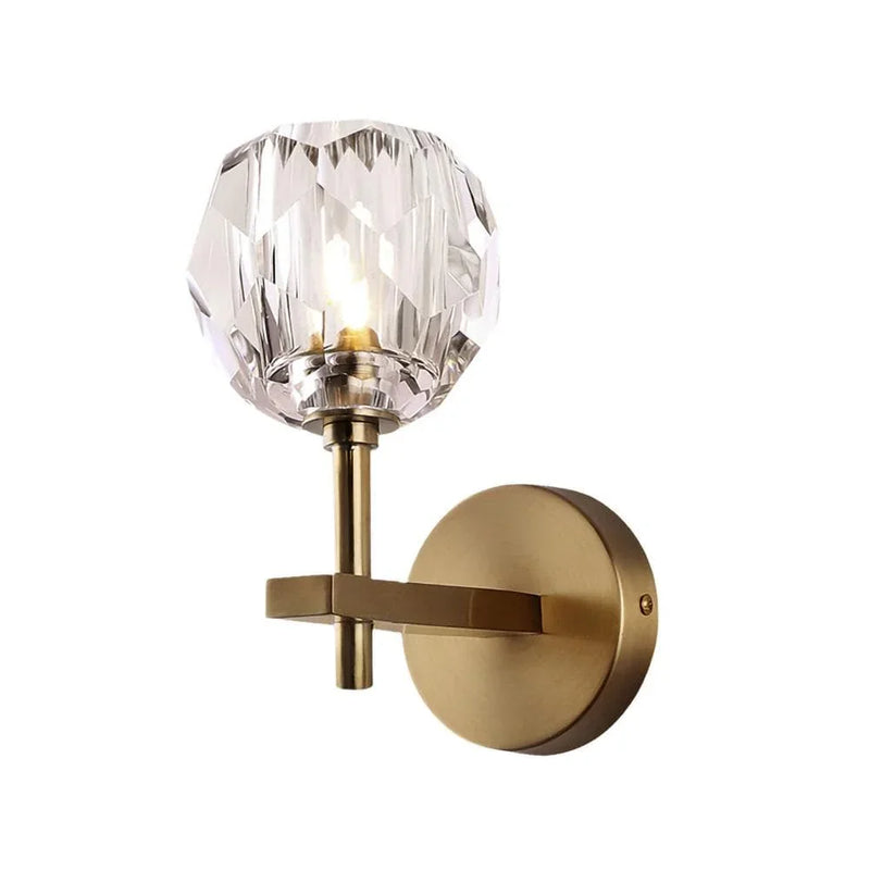 Modern brass wall sconce with faceted crystal globe shade, elegant lighting for bedroom or hallway